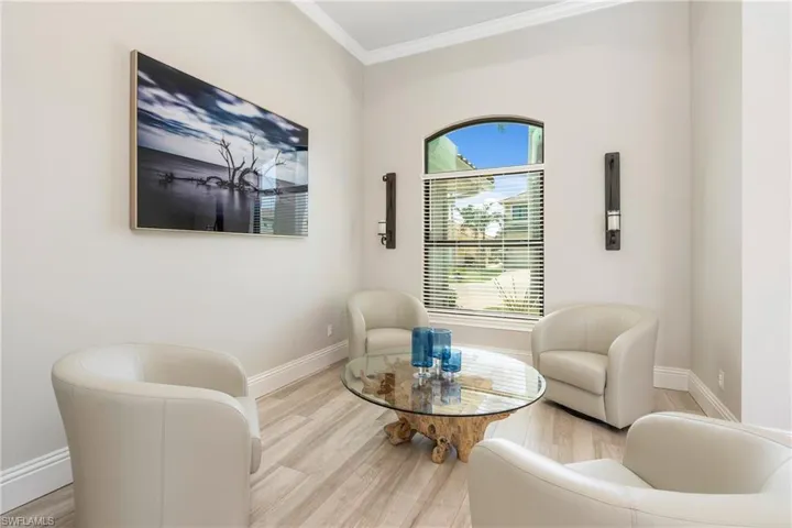 Sitting room with baseboards, ornamental molding, and wood finished floors