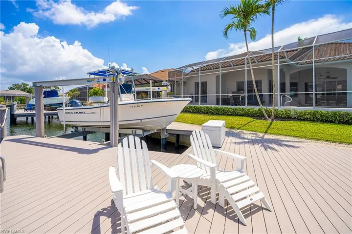 Dock area featuring boat lift, a water view, and a lanai