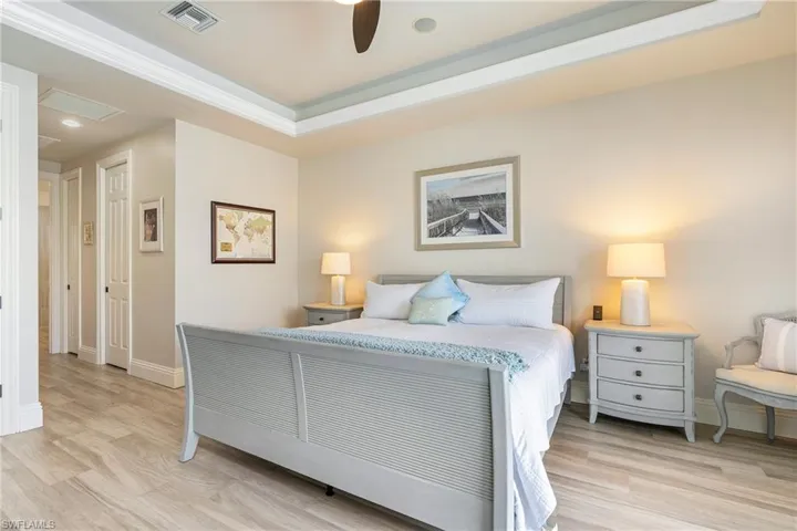 Bedroom with light wood-style flooring, baseboards, ceiling fan, and visible vents