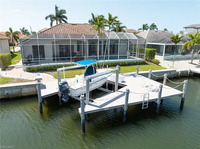 View of dock featuring a water view, boat lift, and an outdoor pool