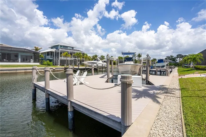 Dock area featuring boat lift and a water view