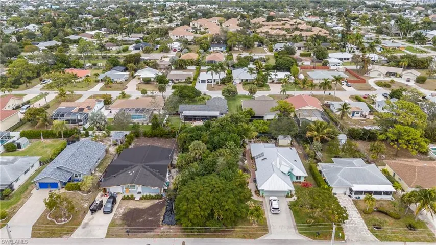 Aerial view of property and surrounding area featuring nearby suburban area