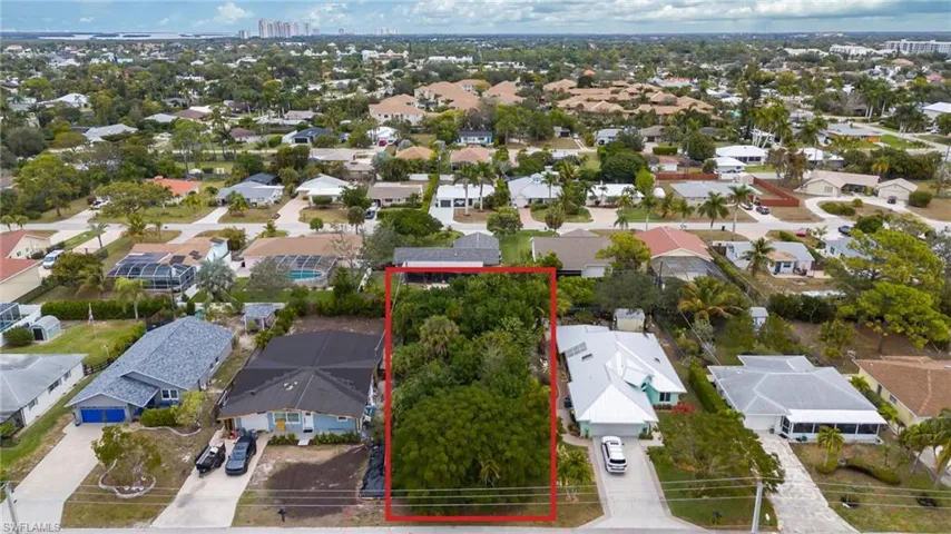 Aerial view of property and surrounding area featuring property boundaries highlighted and nearby suburban area