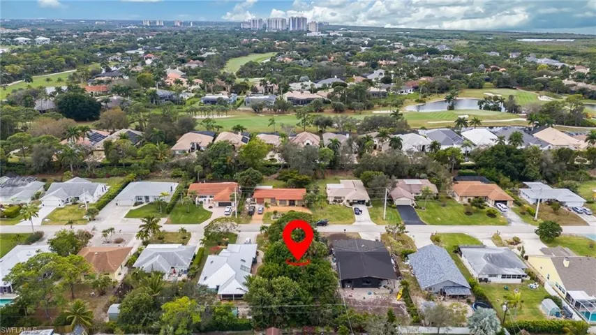 View of property location featuring a golf course and nearby suburban area