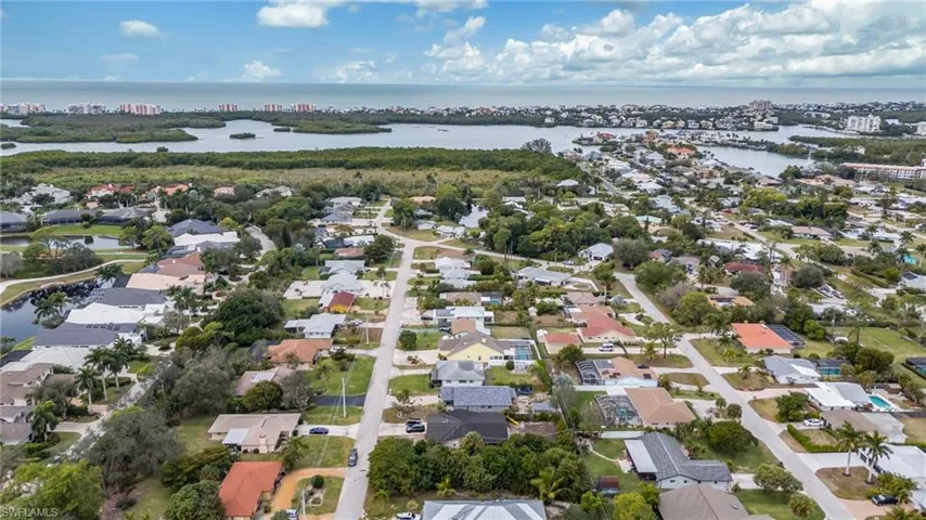 Aerial view of property and surrounding area with nearby suburban area and a large body of water