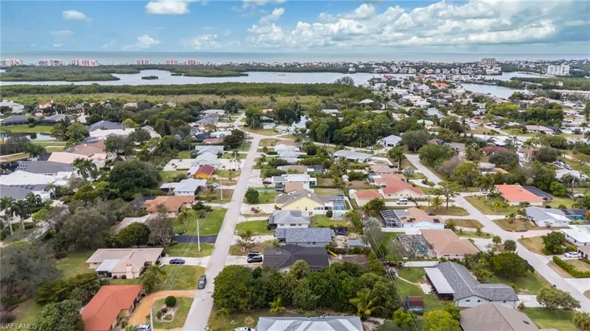 Aerial view of property and surrounding area featuring a large body of water and nearby suburban area