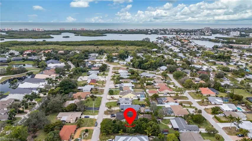 Aerial view of property and surrounding area featuring nearby suburban area and a large body of water