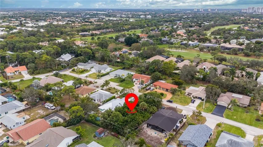 Aerial view of property and surrounding area with nearby suburban area and a golf club