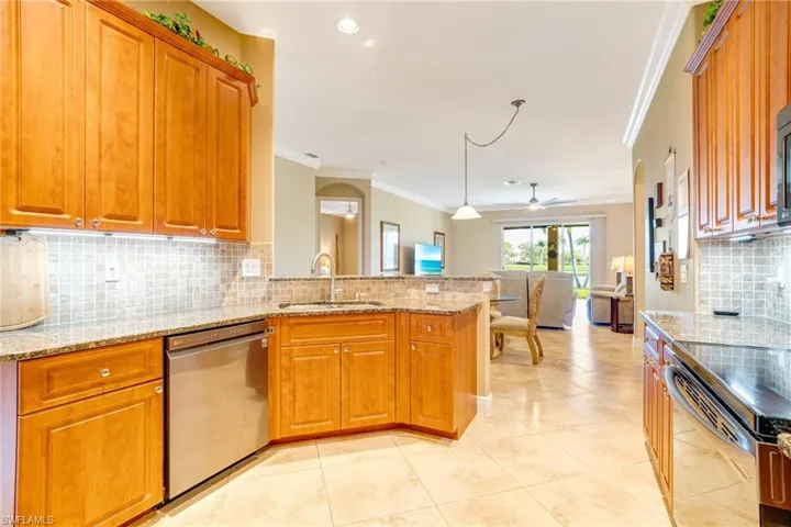 Kitchen featuring a peninsula, range with electric cooktop, a sink, open floor plan, and dishwasher