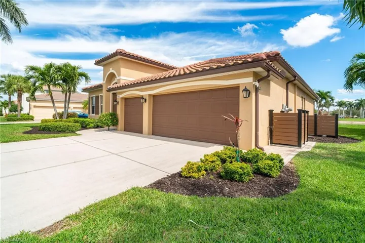 Mediterranean / spanish home with stucco siding, a front yard, a garage, driveway, and a tiled roof