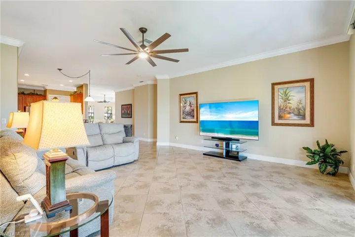 Living room with ceiling fan, ornamental molding, recessed lighting, and baseboards
