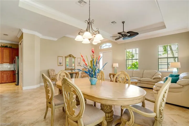 Dining room with crown molding, visible vents, and a tray ceiling