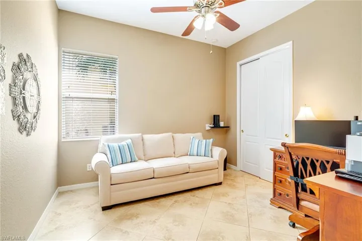 Home office featuring light tile patterned flooring, ceiling fan, and baseboards