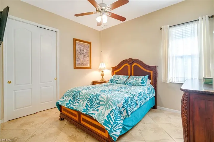 Bedroom with light tile patterned floors, a ceiling fan, and baseboards