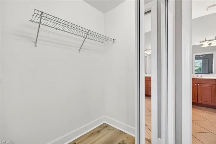 Walk in closet with light wood-style floors