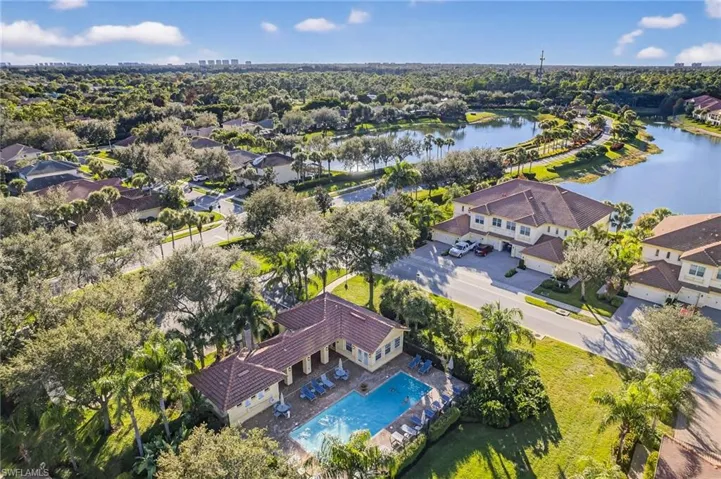Aerial perspective of suburban area featuring a nearby body of water and a pool