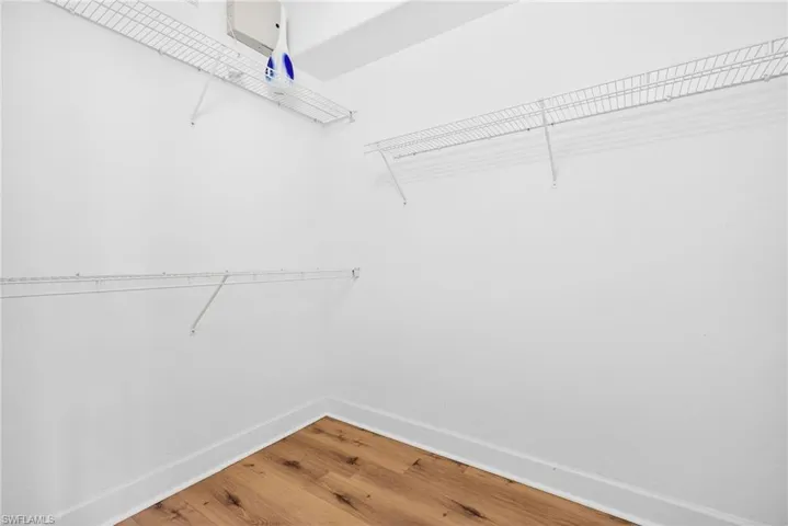 Walk in closet with wood finished floors