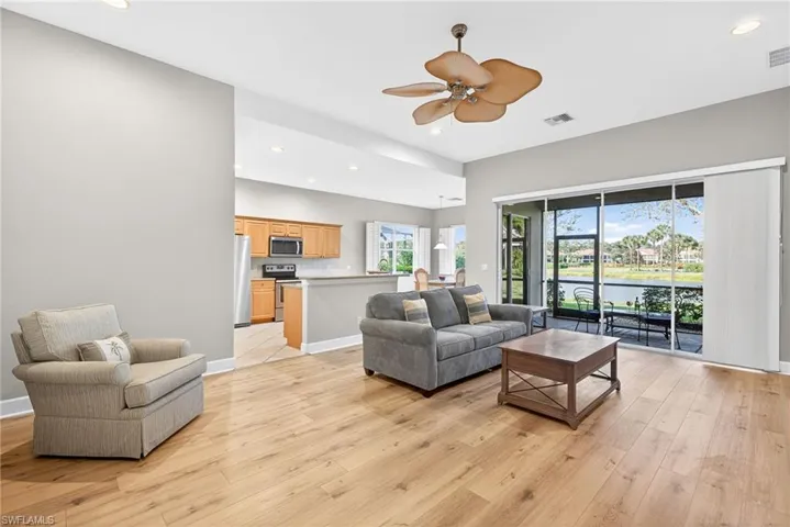 Living room featuring recessed lighting, a water view, light wood finished floors, and ceiling fan