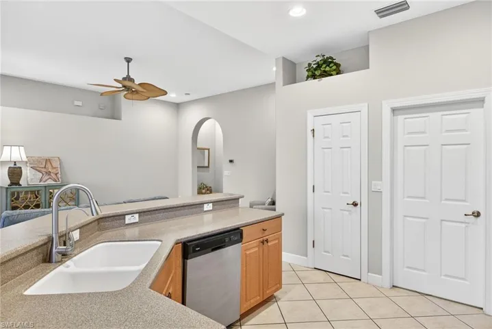 Kitchen with stainless steel dishwasher, light tile patterned floors, open floor plan, recessed lighting, and ceiling fan