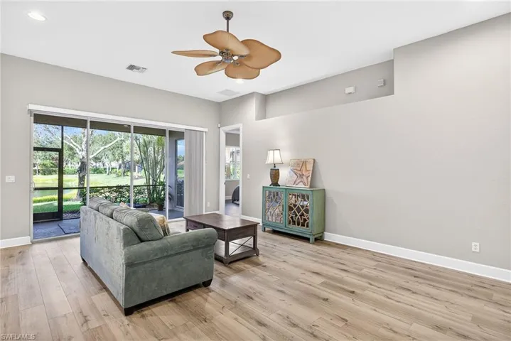 Living room featuring light wood-type flooring, a ceiling fan, and recessed lighting