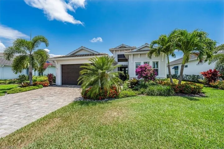 View of front of property featuring a garage and a front yard