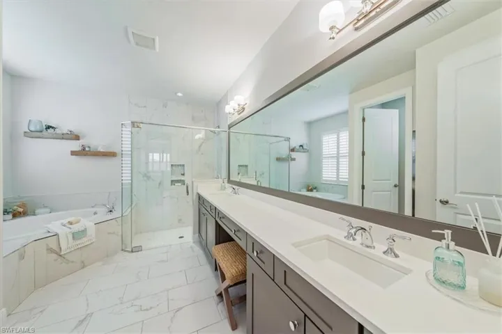 Bathroom featuring vanity and separate shower and tub
