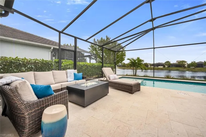View of patio / terrace featuring an outdoor living space with a fire pit, a water view, and glass enclosure