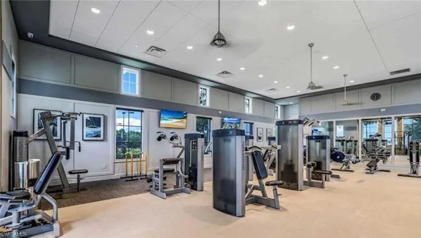 Workout area featuring a high ceiling and light carpet