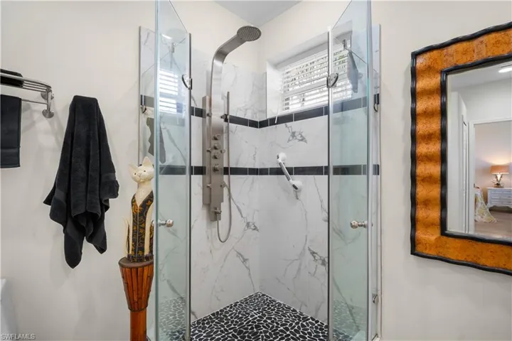 Full bath with a marble finish shower