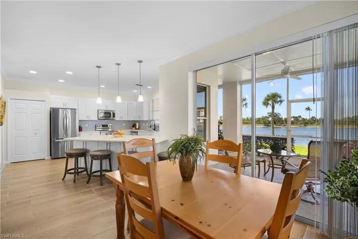 Dining area with ornamental molding, light wood-type flooring, a water view, recessed lighting, and a ceiling fan