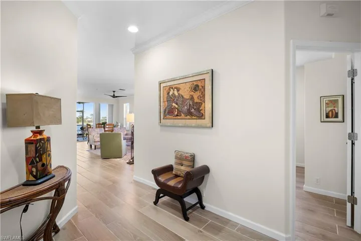 Hall featuring wood finish floors, ornamental molding, and recessed lighting