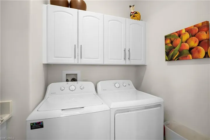 Laundry area with cabinet space and washing machine and clothes dryer