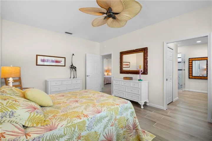 Bedroom with wood tiled floors and a ceiling fan