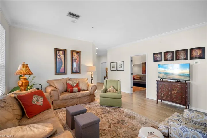 Living room featuring ornamental molding and wood finished floors