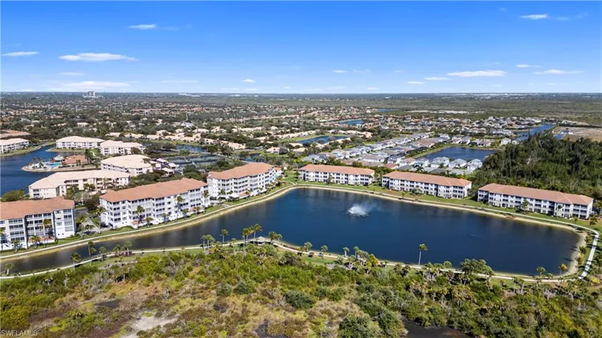 Drone / aerial view of apartment complex and a large body of water