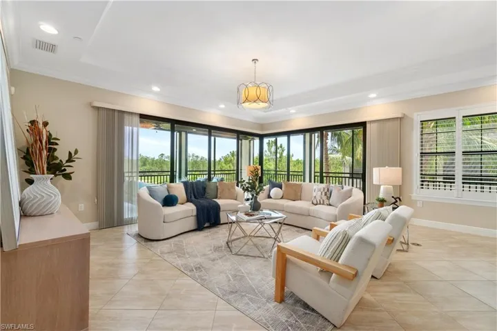 Living room featuring healthy amount of natural light, recessed lighting, and crown molding