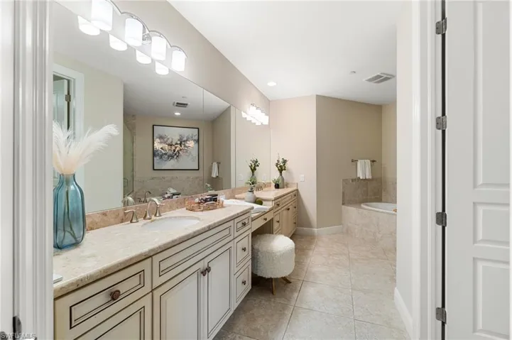 Bathroom with vanity, a bath, tile patterned flooring, and baseboards