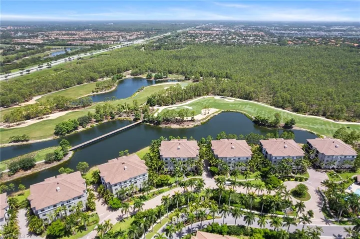 Aerial view of property and surrounding area with a large body of water, a local golf course, and nearby suburban area