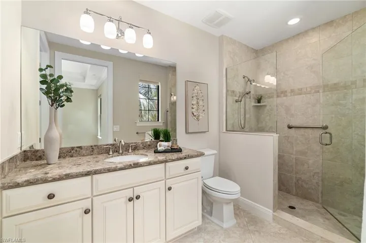 Bathroom with vanity, a shower stall, and toilet