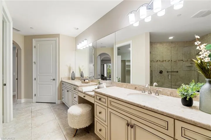 Bathroom with vanity, a stall shower, tile patterned floors, and baseboards