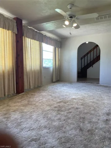 Empty room with carpet flooring and ceiling fan