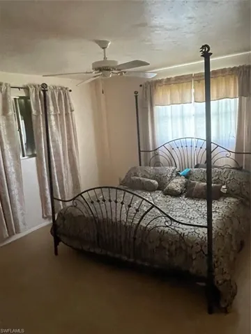 Carpeted bedroom featuring ceiling fan