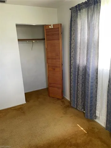 Unfurnished bedroom featuring carpet and a closet