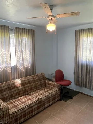 Tiled living room featuring ceiling fan