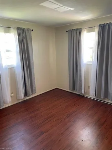 Empty room with dark wood-type flooring