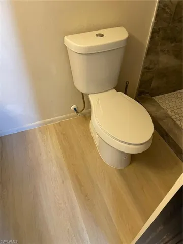 Bathroom featuring a shower, hardwood / wood-style flooring, and toilet