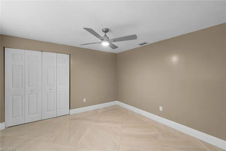 Unfurnished bedroom with visible vents, a closet, a ceiling fan, and baseboards