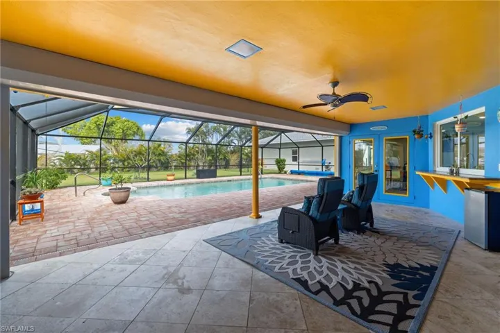View of patio / terrace with ceiling fan, glass enclosure, and an outdoor pool