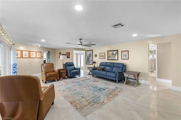 Living room featuring recessed lighting, visible vents, ceiling fan, and baseboards