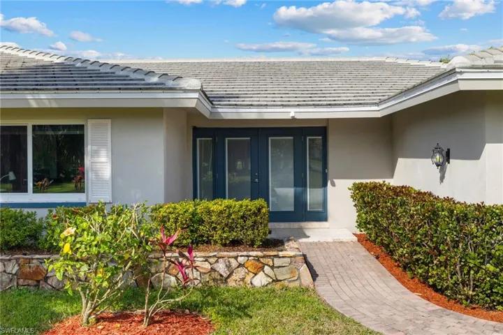 Property entrance featuring a tile roof and stucco siding